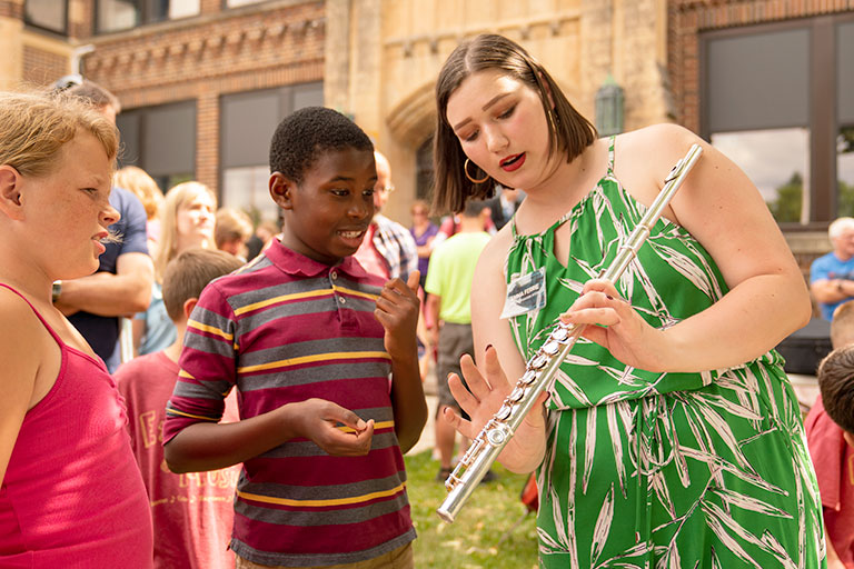 Nonprofit worker helping child with instrument